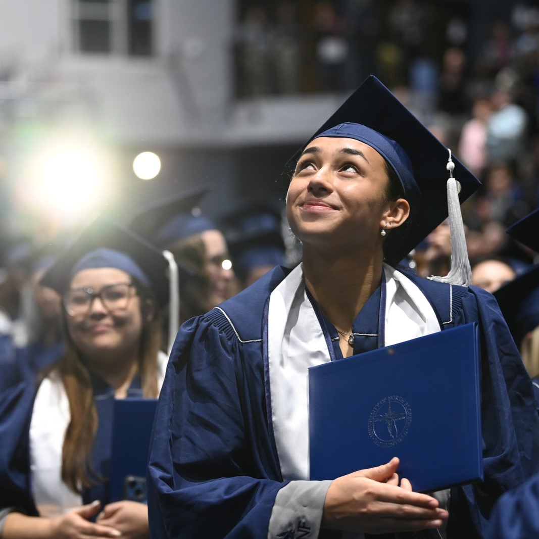 UNF student wearing a graduation hat looking up