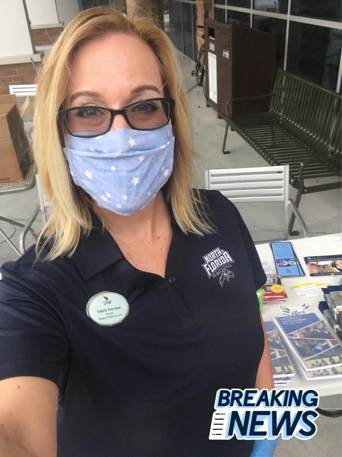 Valerie Morrison massing out Student Health Services supplies at UNF waering a mask