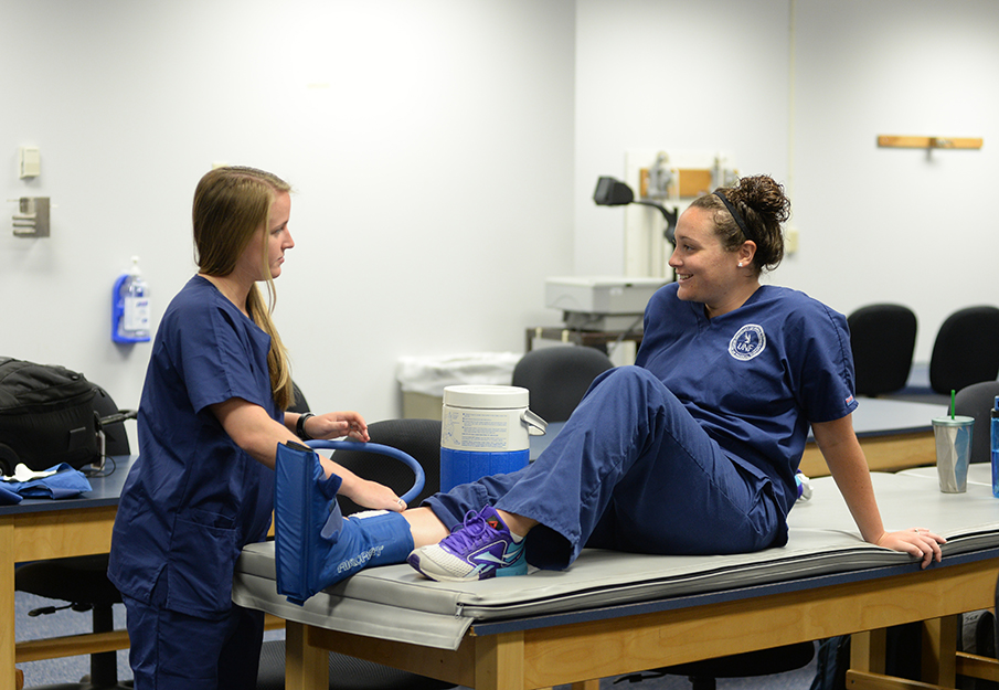 PT students putting boot on leg