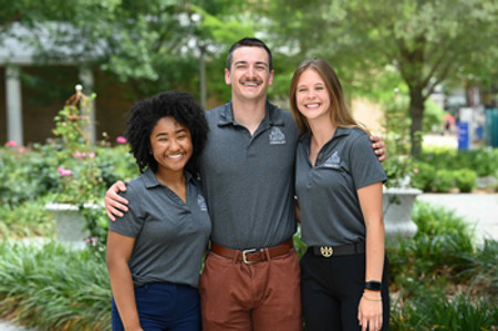 Three UNF EIM Students standing and smiling