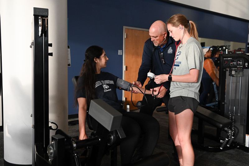 Student receives a blood pressure check during fitness lab session
