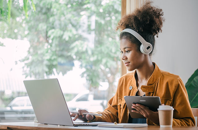 student on a laptop with headphones on