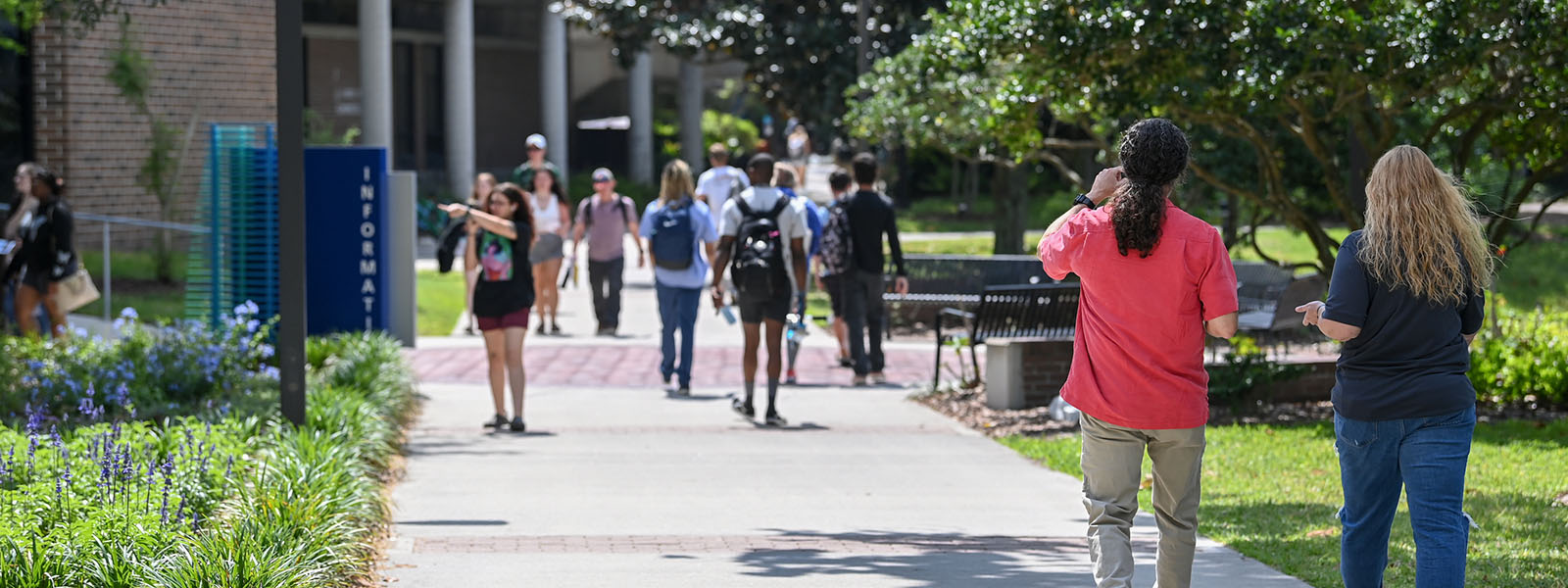 students walking near Brooks College of Health on a sidewalk