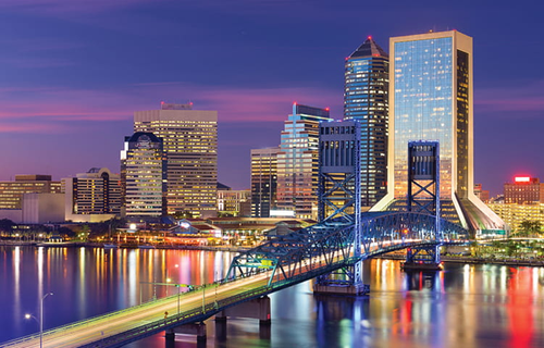 Jacksonville downtown at dusk with bridge and river in foreground