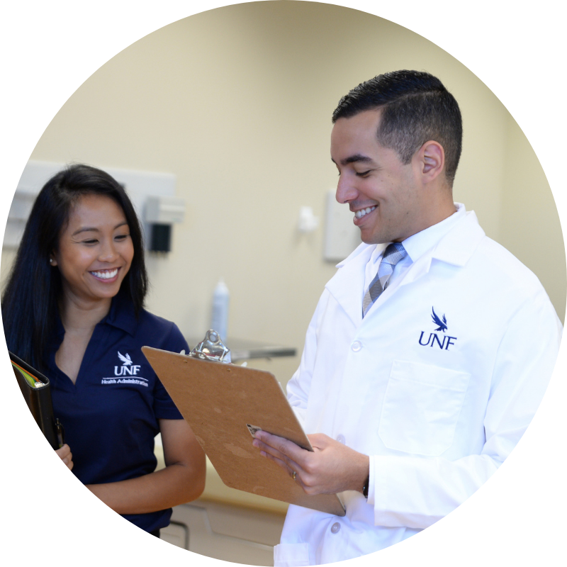 two mha students with a clipboard