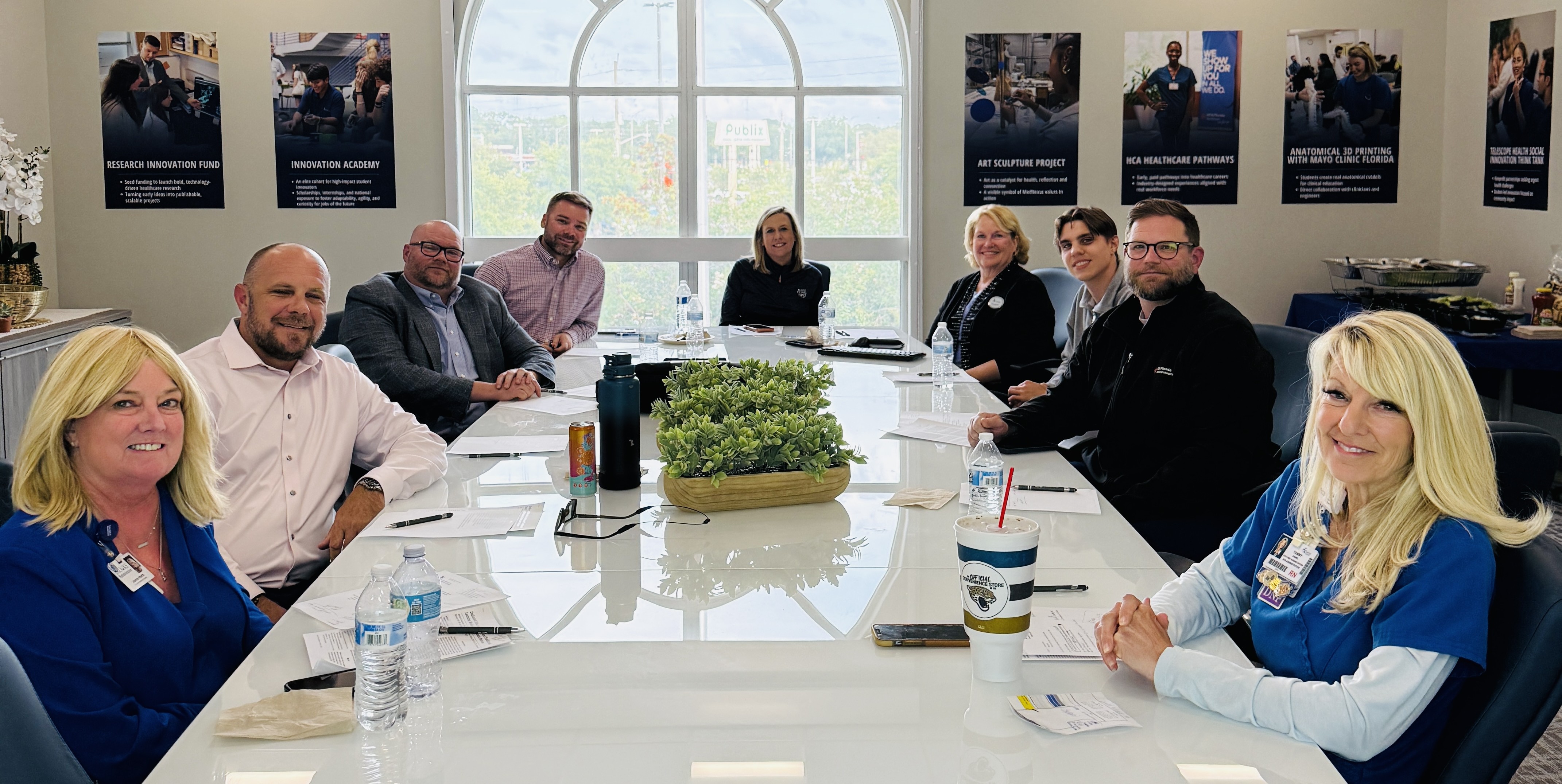 The Nursing Advisory board members at a conference table sitting and smiling. 