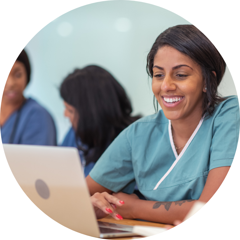 Nurse at a computer smiling
