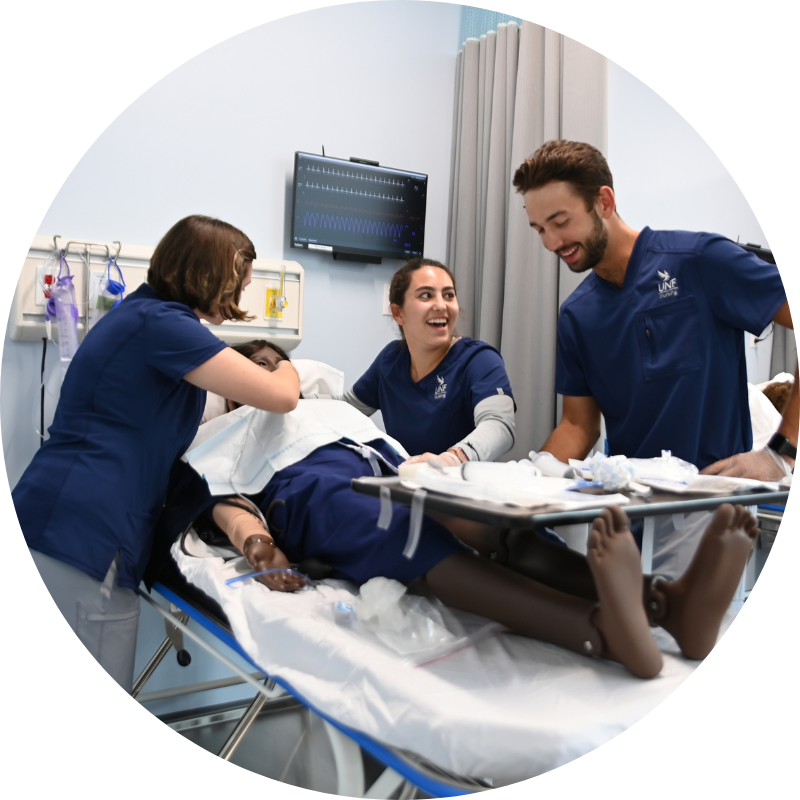 Three nursing students with a cadaver on a nursing bed
