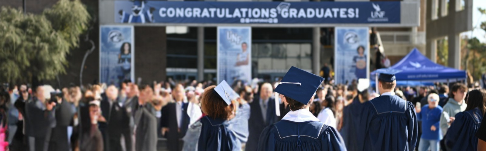Graduating students walking up to the arena building