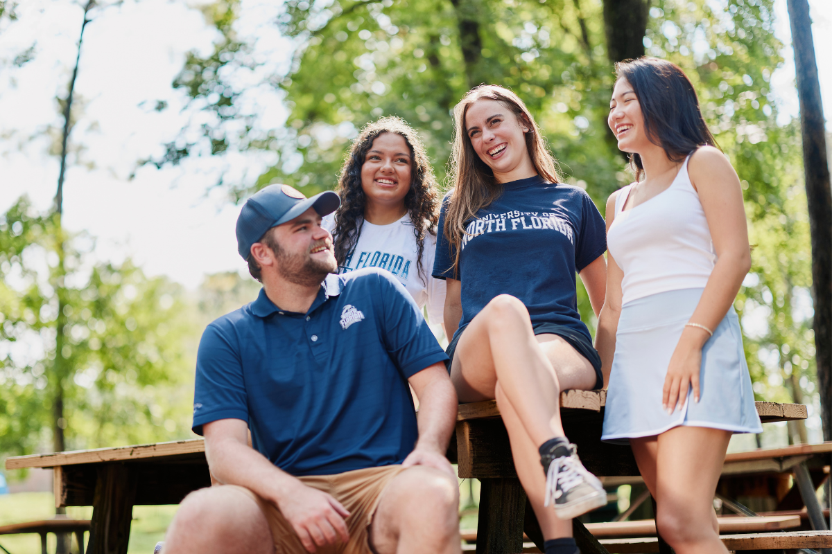Four UNF students talking outdoors on campus