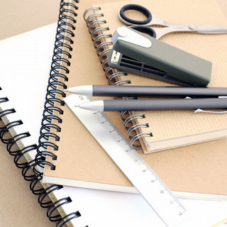 ruler, pens, stapler, and scissors on notebooks