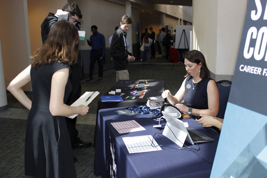 Two students checking in at a table with a career services member