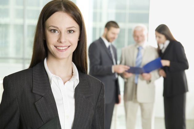 a woman in a suite with three professionals talking in the background