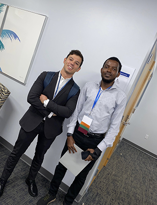 two students standing together at an event