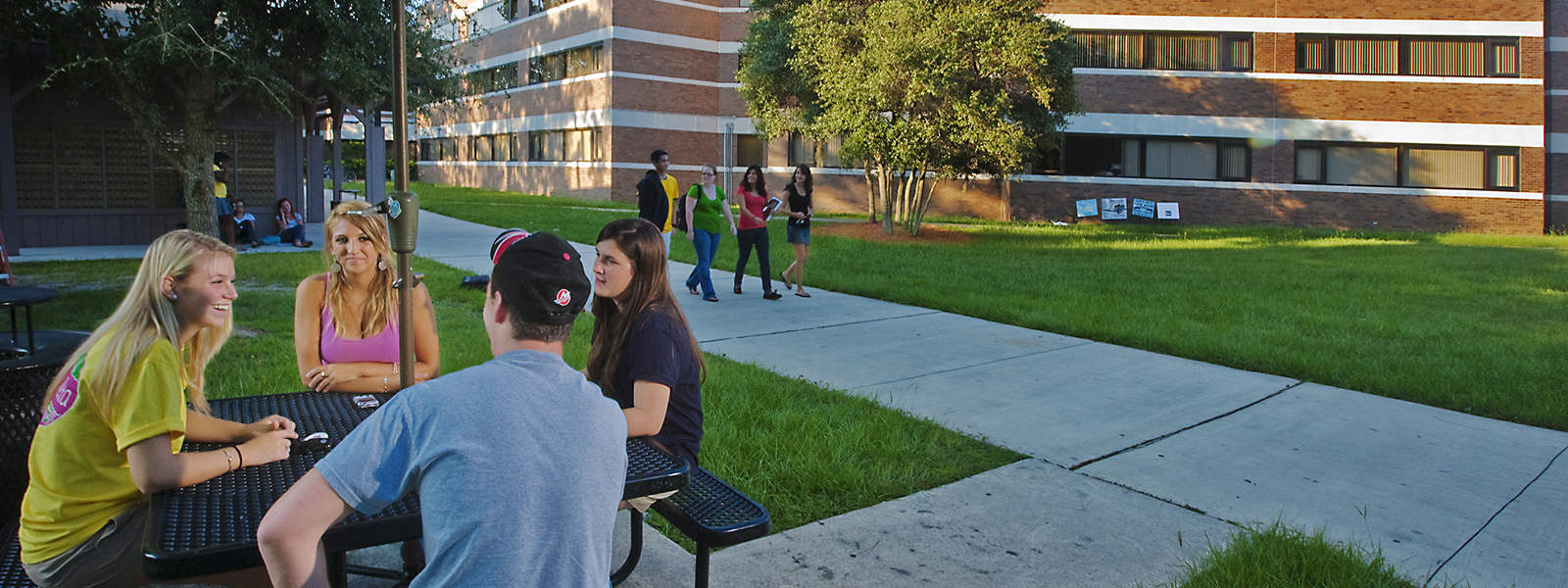 Students chat at a table outside the residence halls.