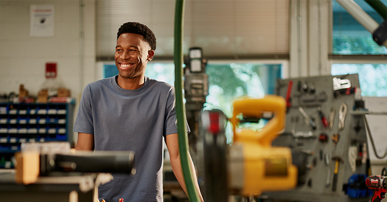 Student smiling while standing in an engineering lab
