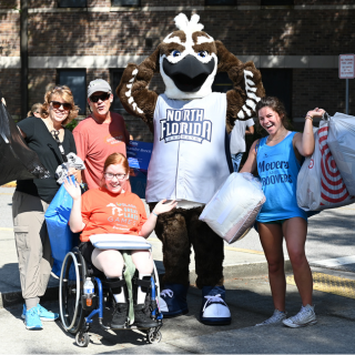 students moving in on campus posing for a picture with Ozzie