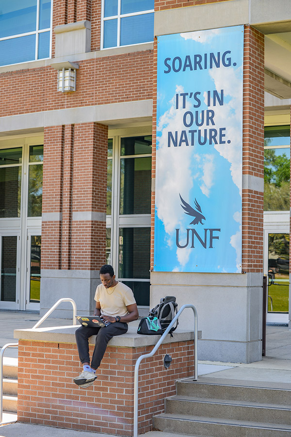 student outside the fine arts building