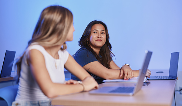 two students with laptops