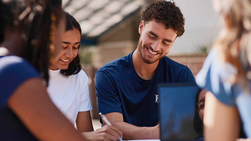 Students studying together at a picnic table