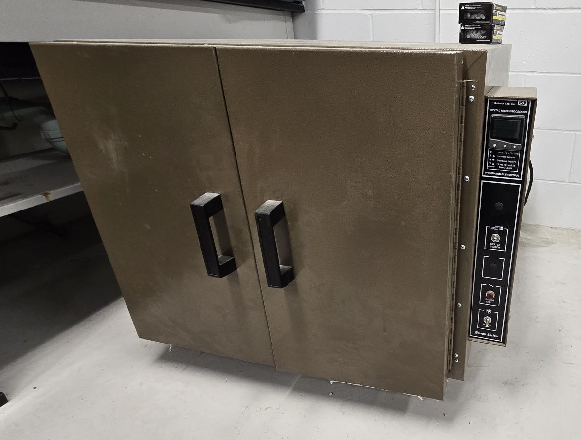 Bench-top laboratory oven with double doors and side control panel