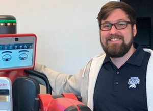 Richard Lentz standing next to a robot