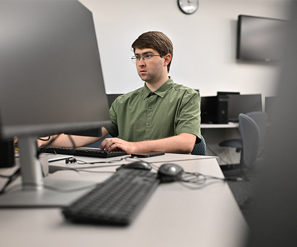 person working on a computer at a desk in a computer lab