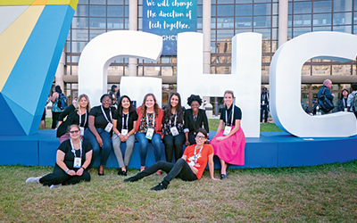 students posing next to the GHC sign