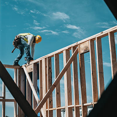 A man standing on a house frame