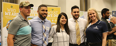 five people standing together smiling