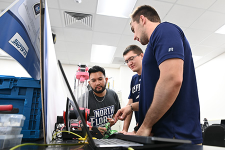 three engineering students working on their final project