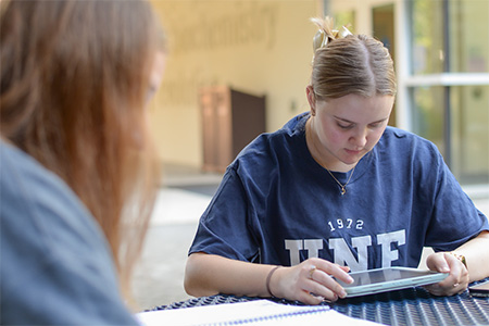 two students studying on a tablet