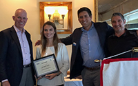 A group of people standing together the woman is holding a certificate