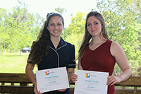 two women holding certificates