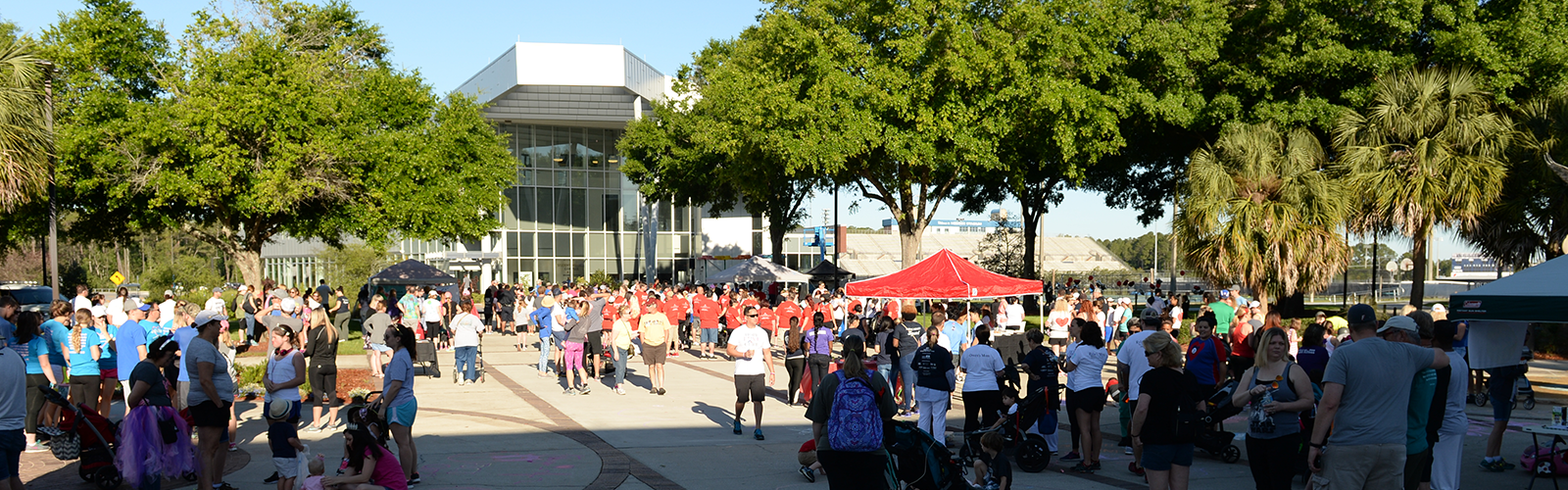 Group of people at an event in the Arena plaza, with some people wearing red shirts