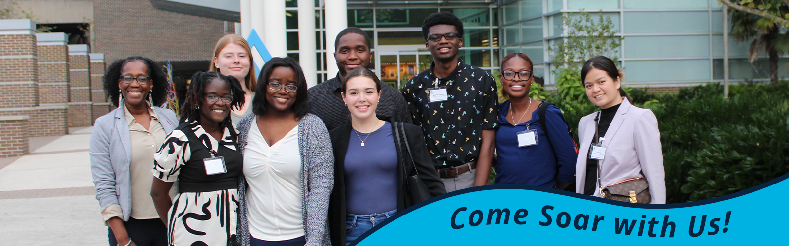 Smiling CASS group wearing business attire; in the bottom right, text saying 'Come Soar with Us'