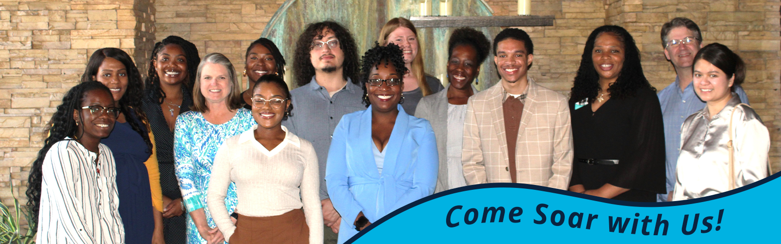 Smiling mentoring group wearing business attire; in bottom right, text saying 'Come Soar with Us'