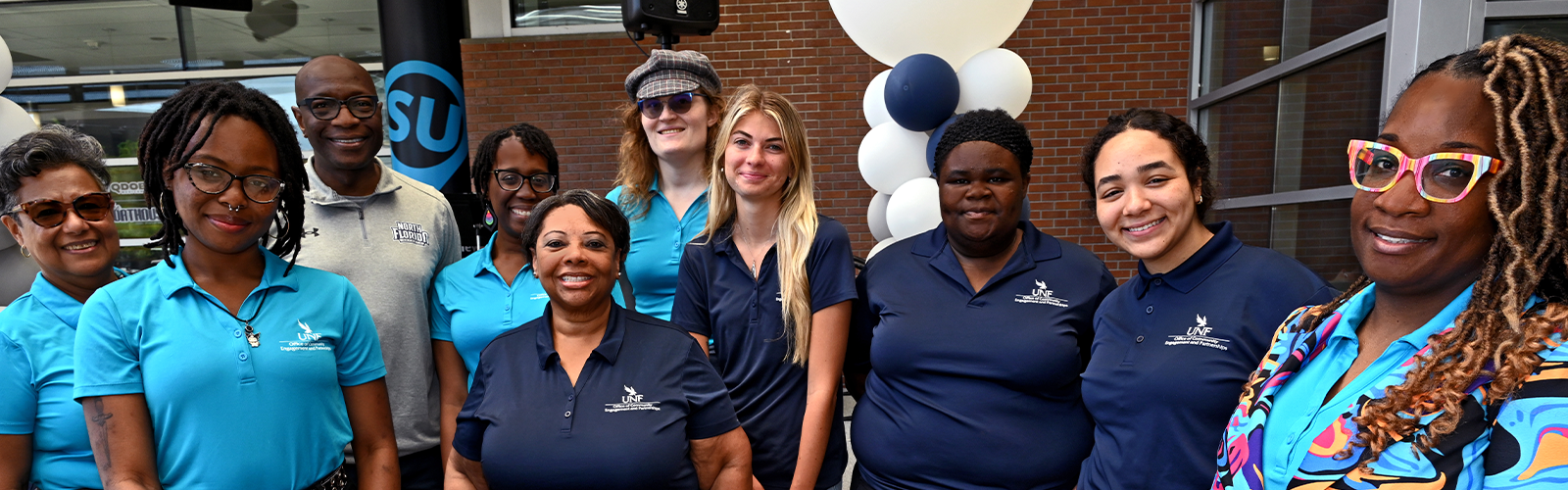 CEP Staff group shot with them smiling and wearing either navy blue, light blue, or gray CEP shirt
