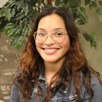 Tatiana smiling and wearing glasses and blue jacket
