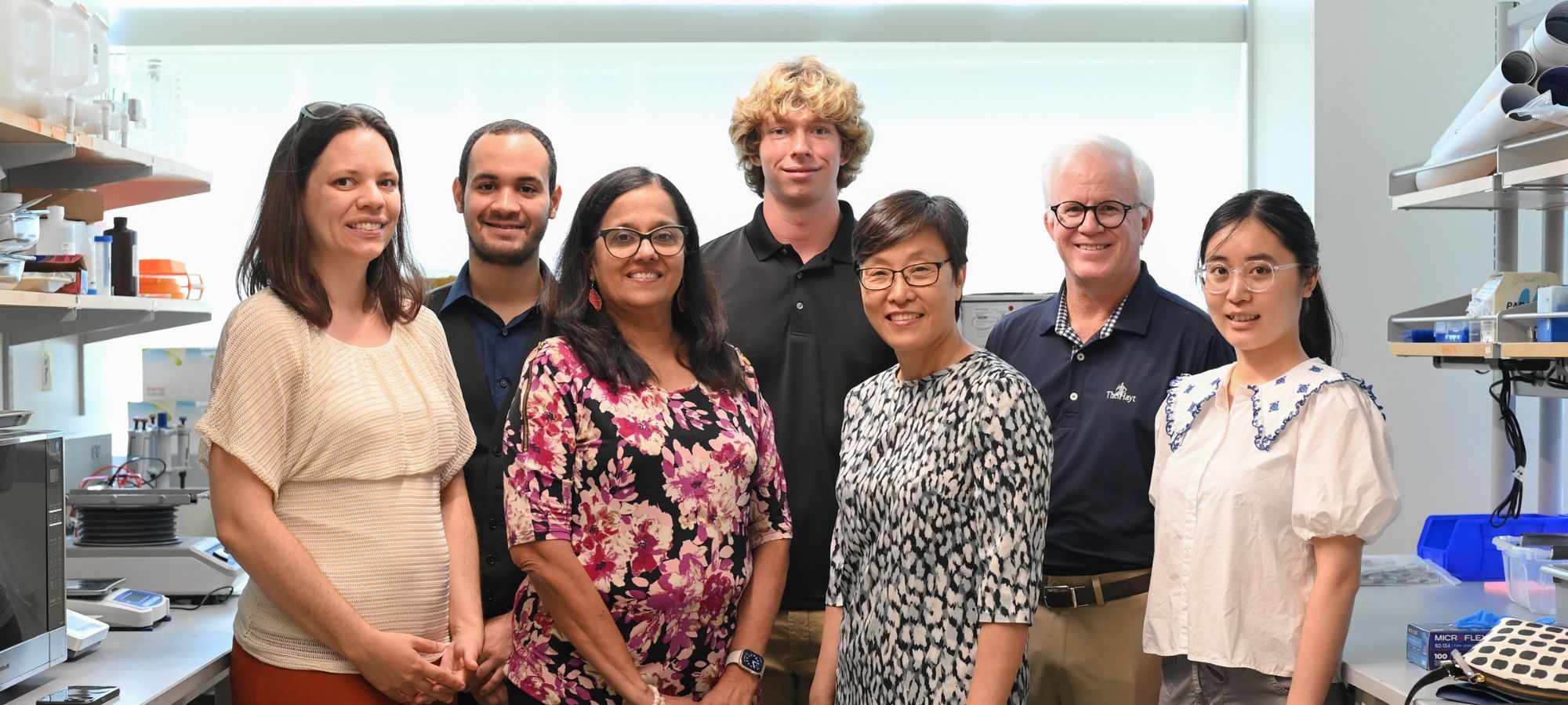 Faculty members with members of the community in a lab