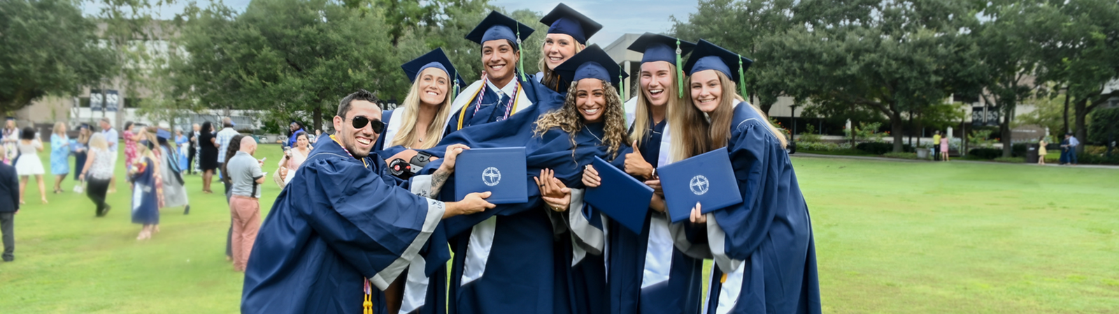 group of graduates holding up a dipolma