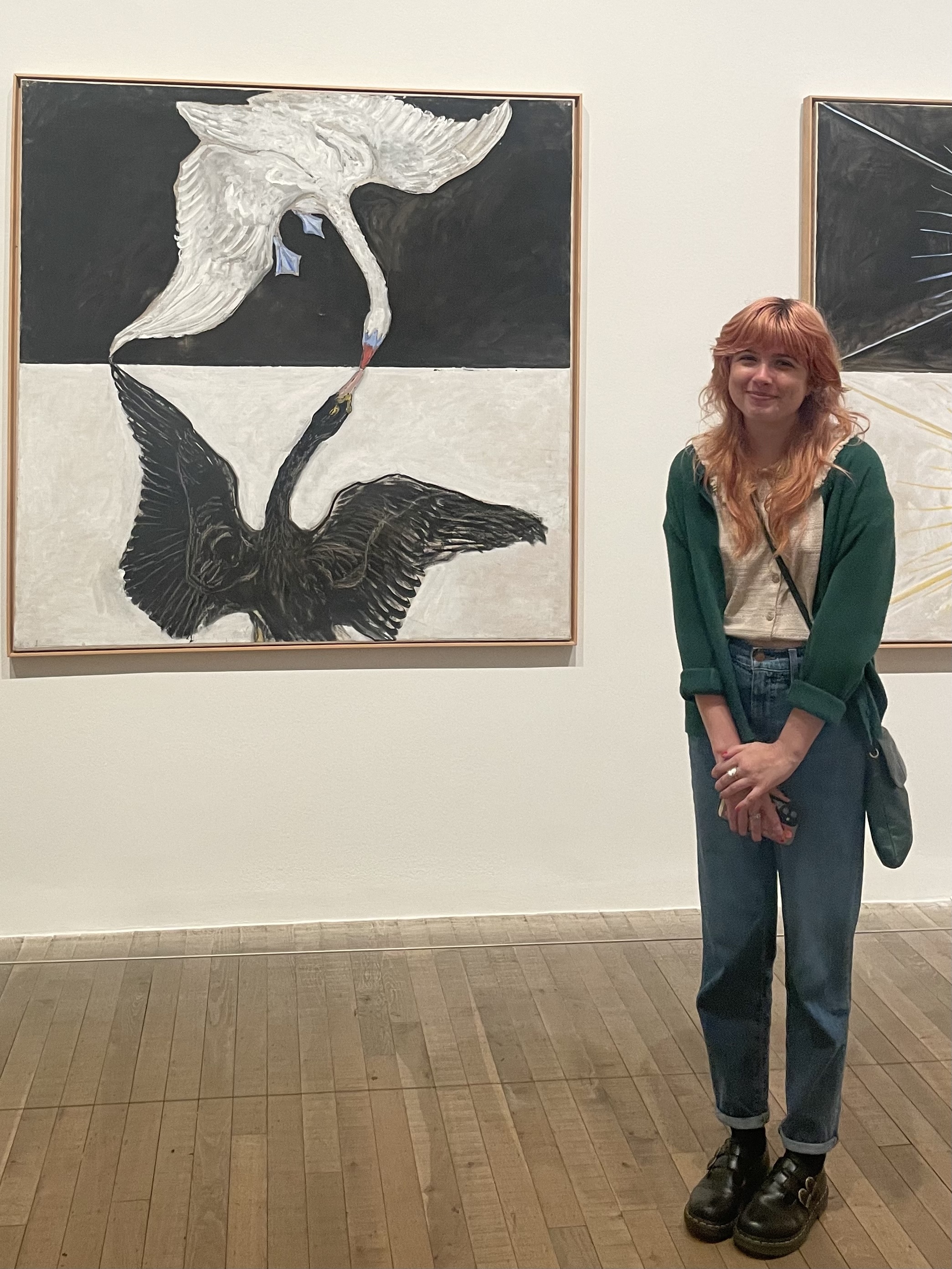 Kodie Mahone standing next to a painting by Hilma af Klint