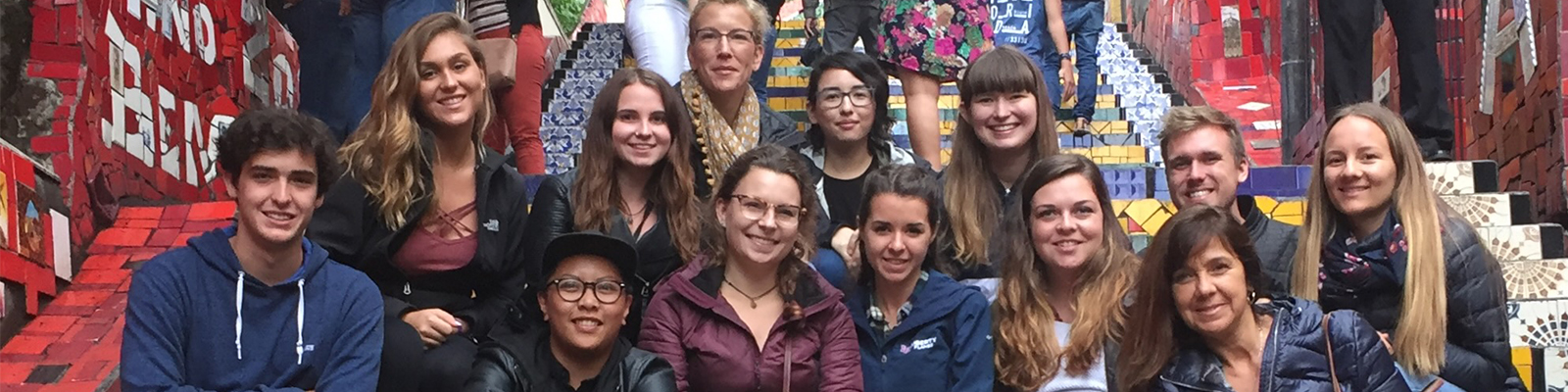 UNF Art students smiling together on the colorful tiled steps of Escadaria Selaron in Rio de Janeiro Brazil