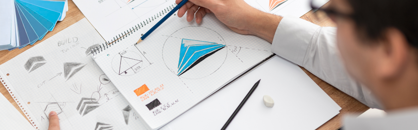 A person sketching a logo on a pad of paper