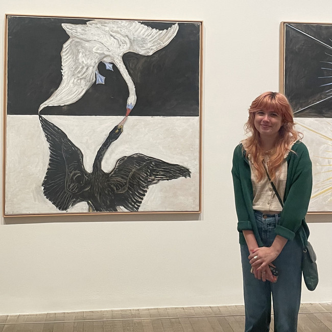 UNF Alumni Kodie Mahone standing infront of wall art