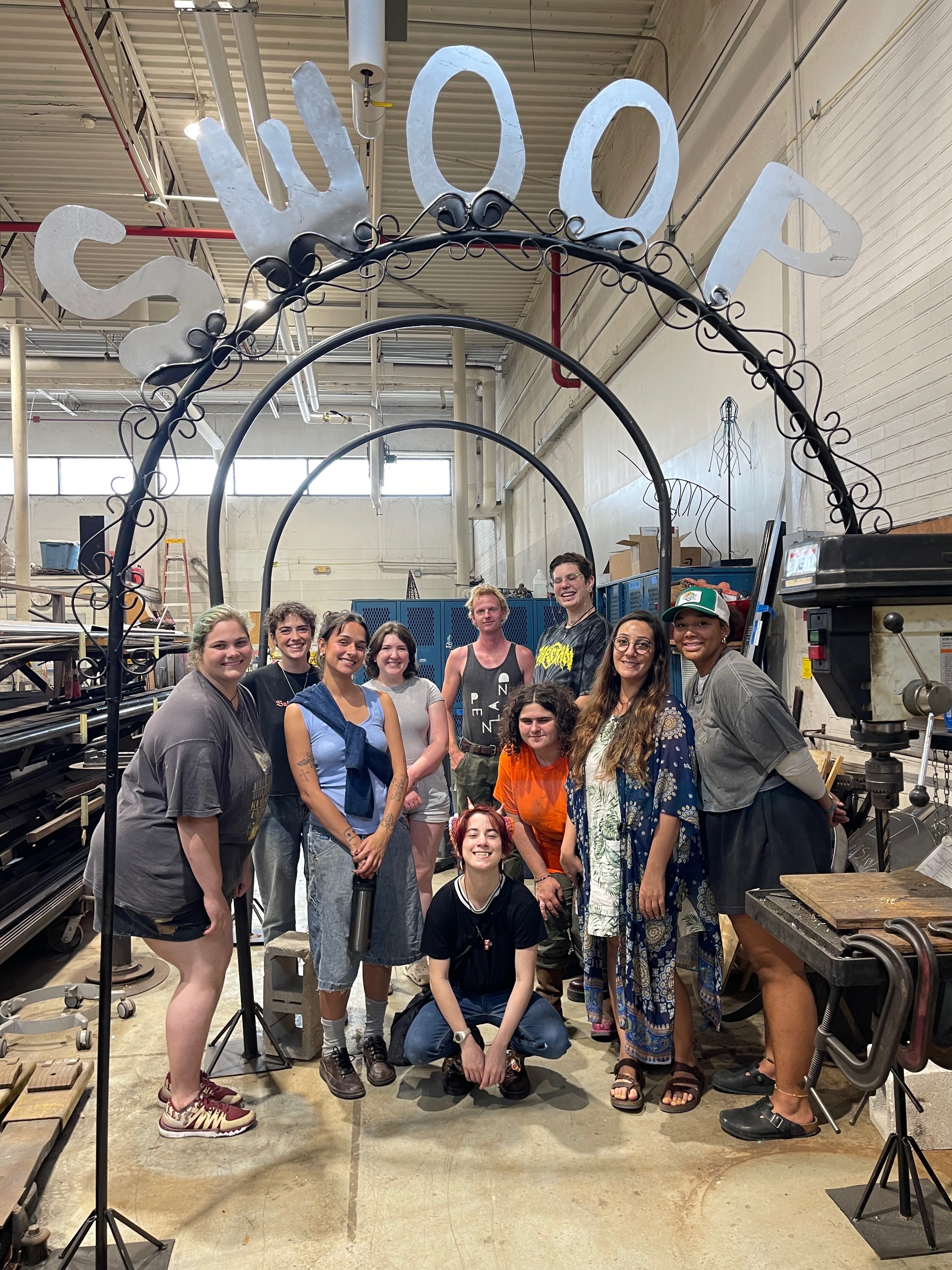 UNF Art students posing together in front of a SWOOP sign