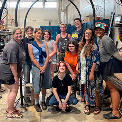 group of art students standing in a workshop posing for a group photo