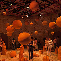 people viewing a ceramics workshop with spherical artwork in the air