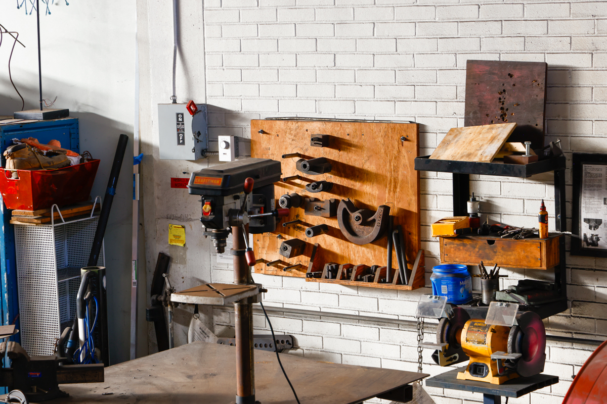 A photo of a workshop showcasing various tools and equipment neatly organized on walls and surfaces.