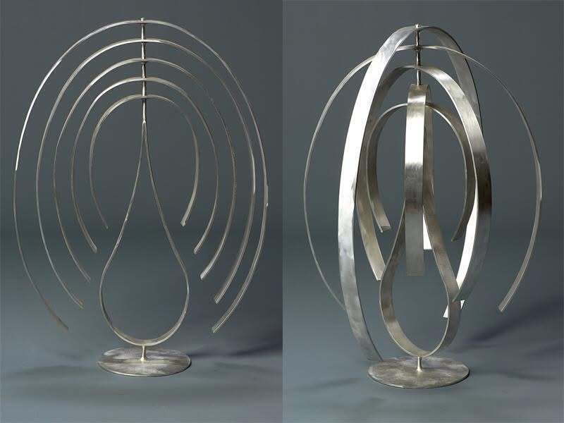 Abstract metal sculpture featuring curved lines and a teardrop shape, showcasing a modern design.